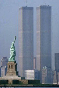 A statue of liberty in front of two towers.