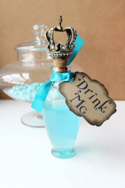 A bottle of blue liquid with a crown on top.