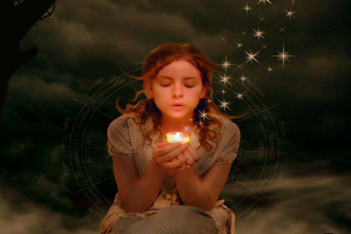 A girl is holding a candle in her hands