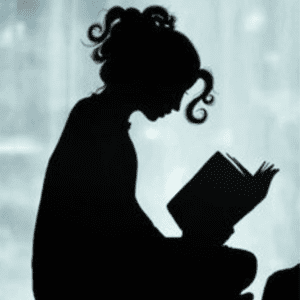 A girl sitting in front of a window reading.